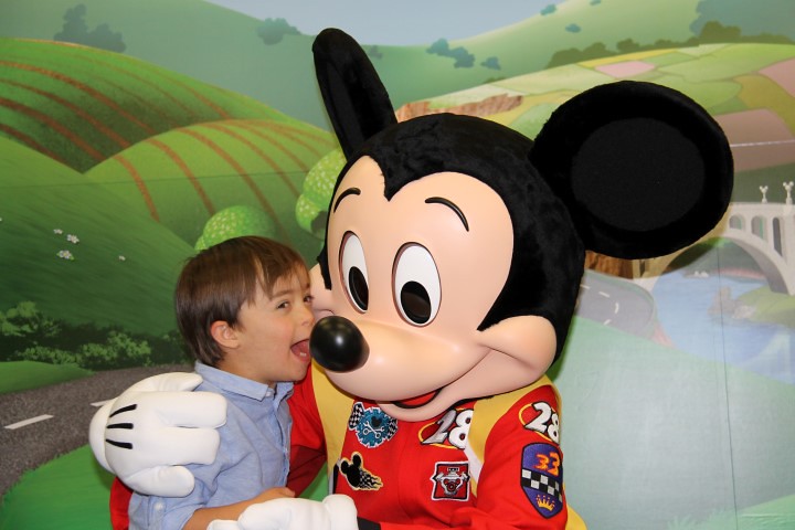 Mickey Mouse knuffelt met een jongetje.